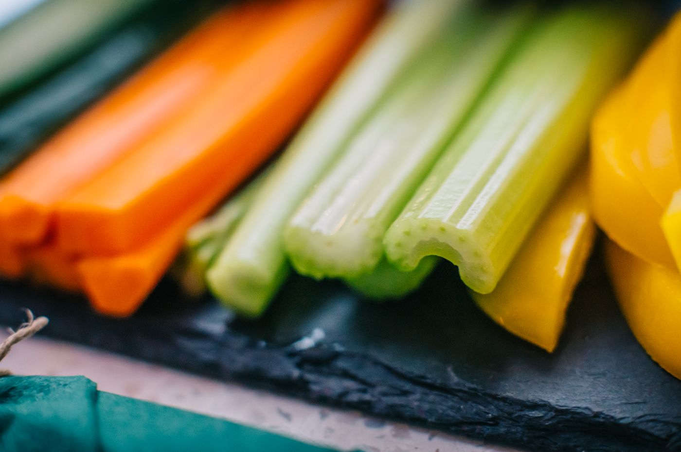 Sticks of carrot, celery, cucumber and pepper on a board
