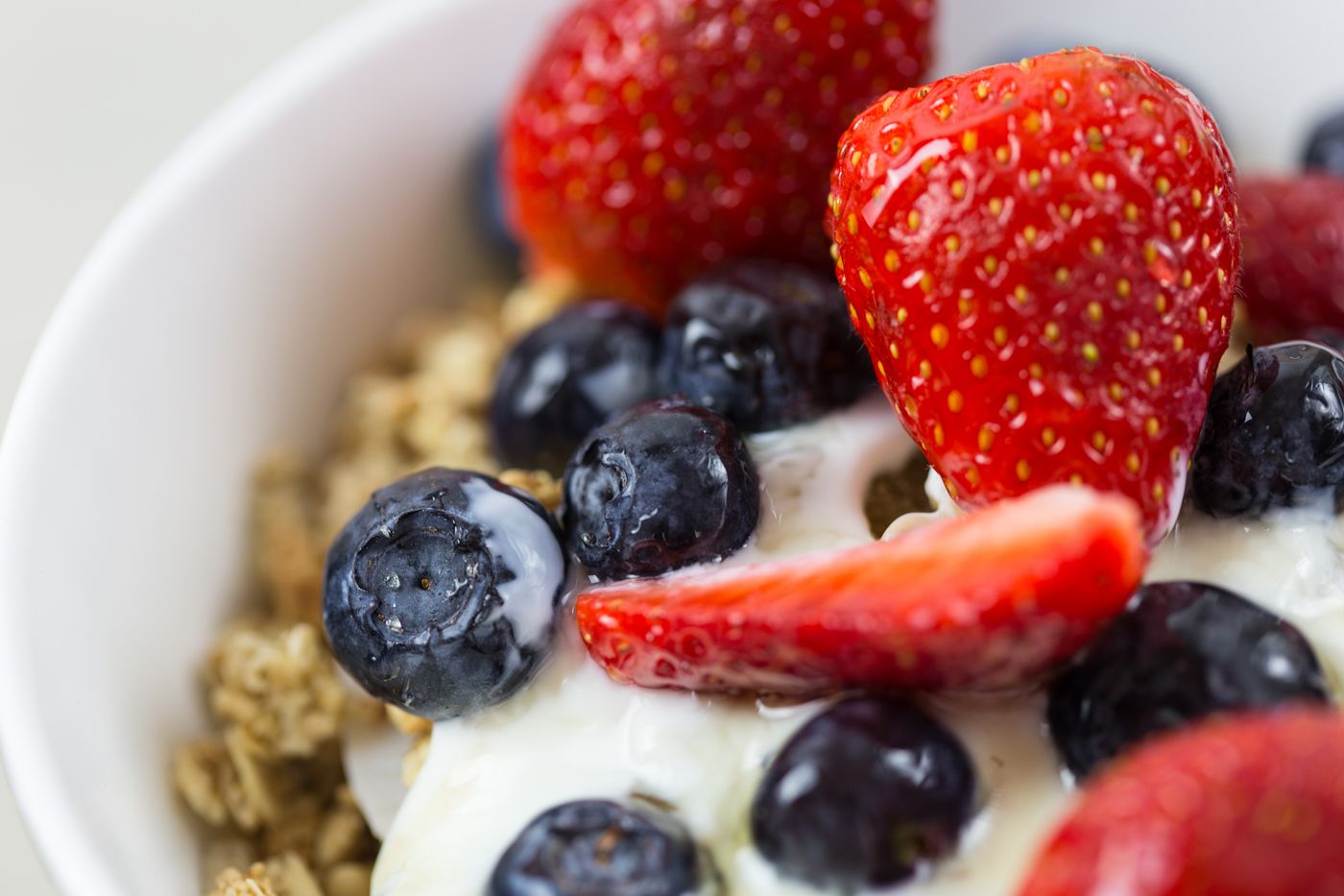 A bowl of yoghurt topped with fresh berries and granola